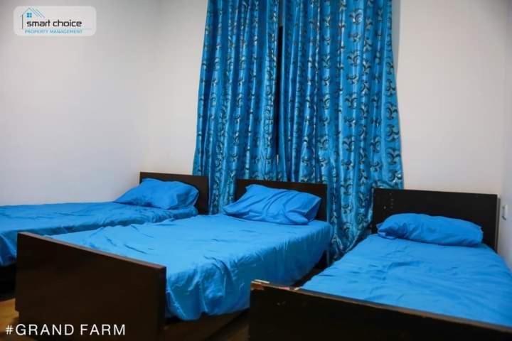 twee bedden in een kamer met blauwe gordijnen bij Green farm in Al Salt