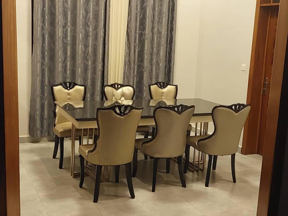 a dining room with a table and chairs at Mwisenix apartment in Kigali