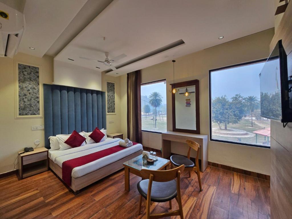 een slaapkamer met een bed en een tafel en een groot raam bij Hotel The SOHO in Chandīgarh