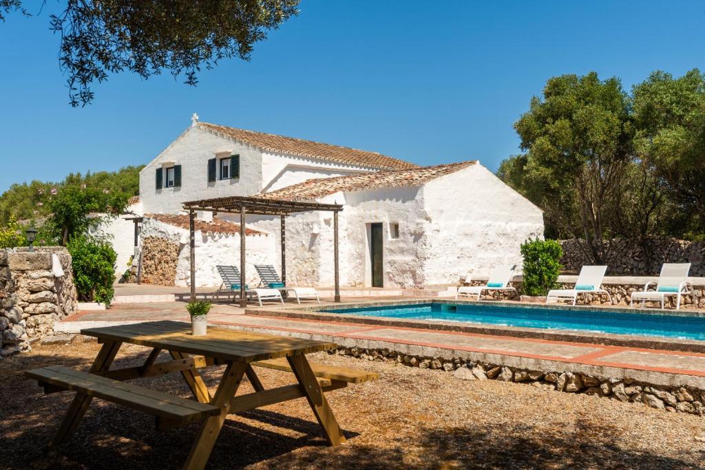 una villa con piscina e tavolo da picnic di Finca Biniparrell Vell a Sant Lluís