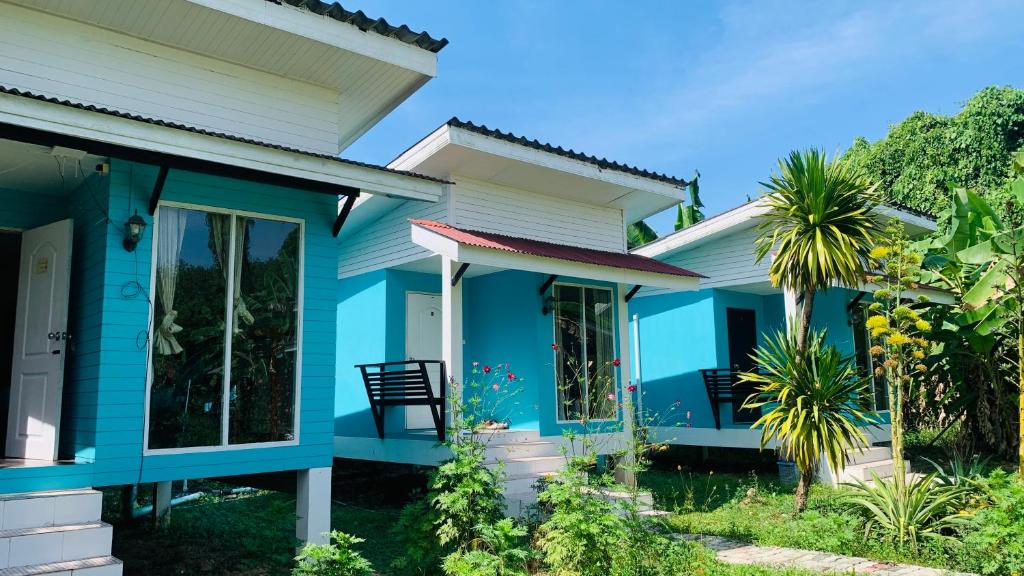 a blue house with a palm tree in front of it at Yada Resort Koh Yao Noi in Ko Yao Noi