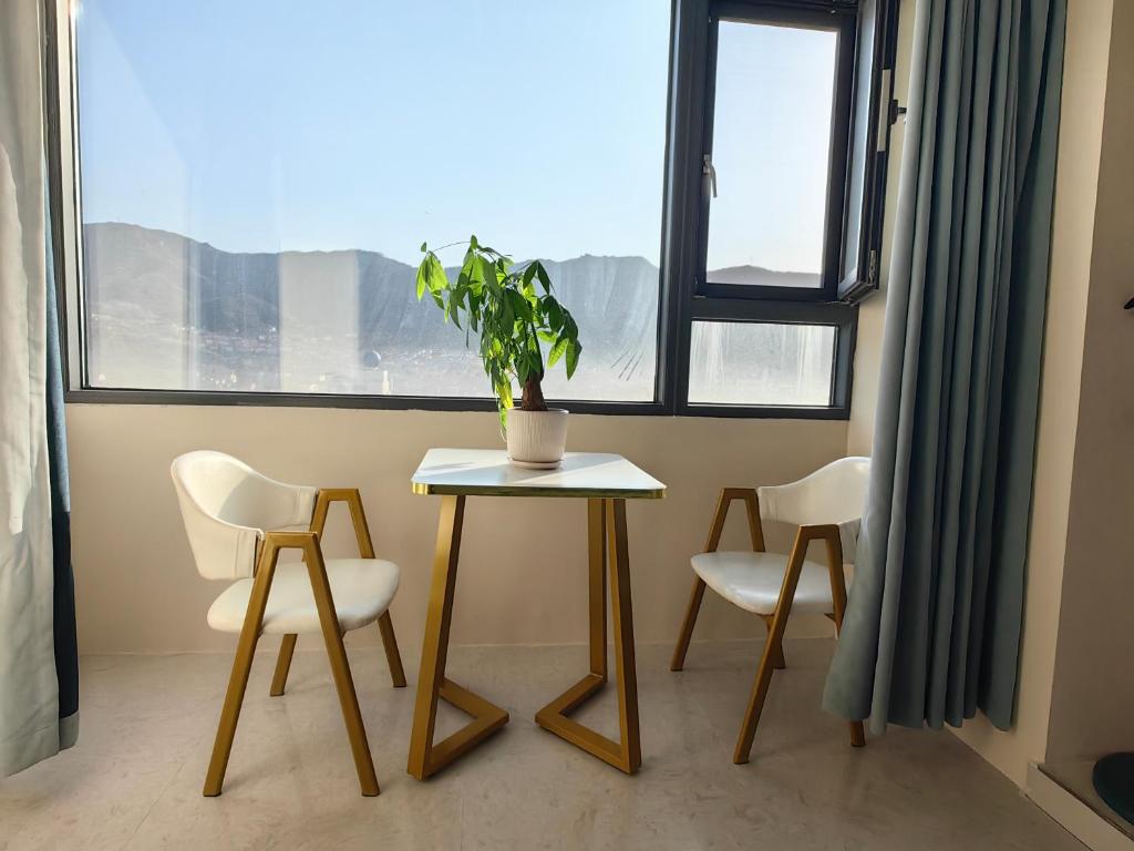 a table and chairs in a room with a potted plant at Xinchen B&B in Ge Dao
