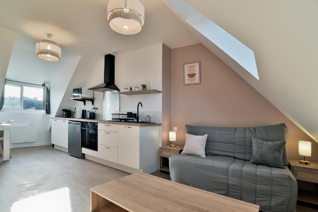 un soggiorno con divano e cucina di Les Trois Rois 6 - Centre Avranches ad Avranches