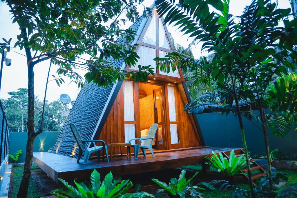 a house with two chairs and a hammock on a porch at Villa Anaa in Habaraduwa Central