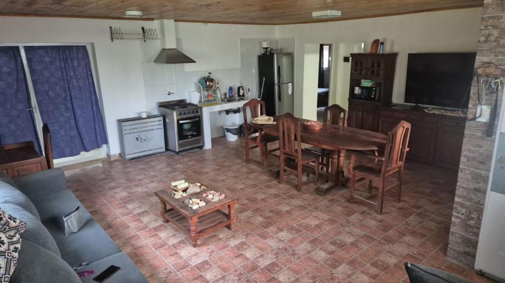 a living room with a table and a kitchen at Complejo Casablanca Plottier in Plottier