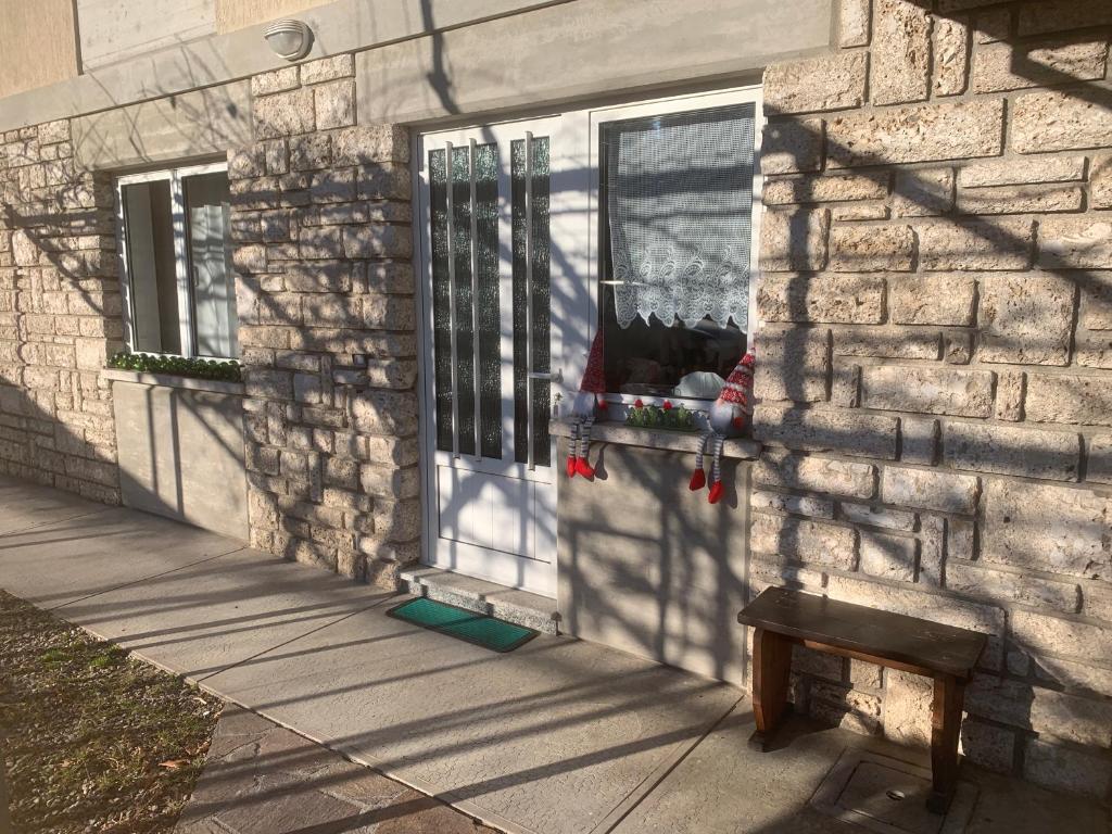 eine Tür eines Hauses mit einer Bank davor in der Unterkunft Appartamento Ape Verde in Piano dʼArta