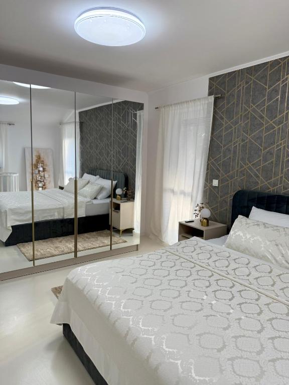 a bedroom with a large white bed and a mirror at Apartmani Beril Lux in Rovinj