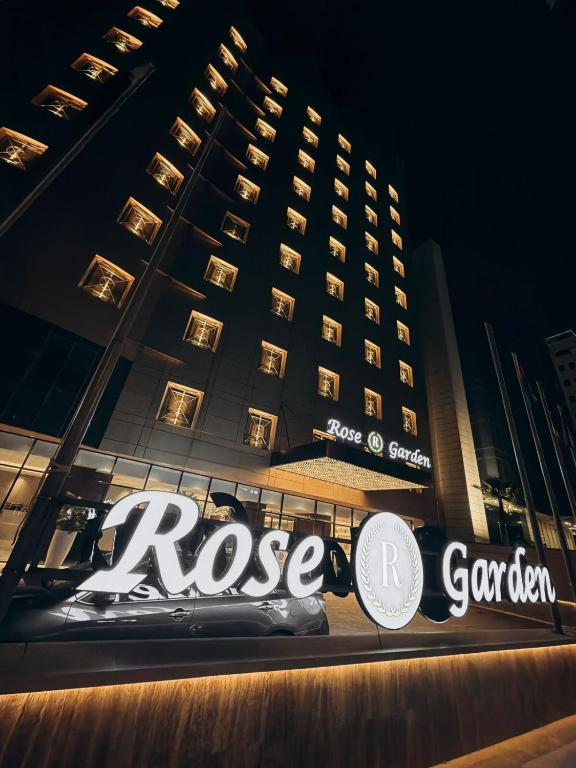a large building with a sign in front of it at Rose Garden Hotel فندق روز جاردن in Riyadh