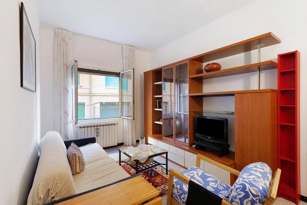 un soggiorno con un divano e una TV di La casetta di Hiba a Diano Marina