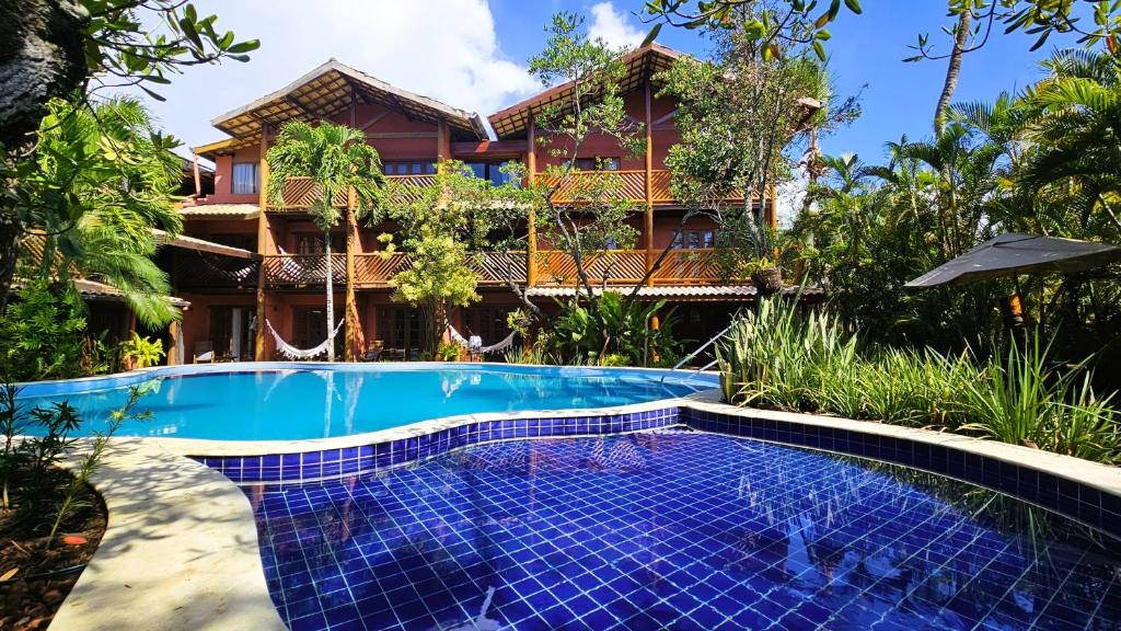 a resort with a swimming pool in front of a building at Pousada Casa do Forte in Praia do Forte