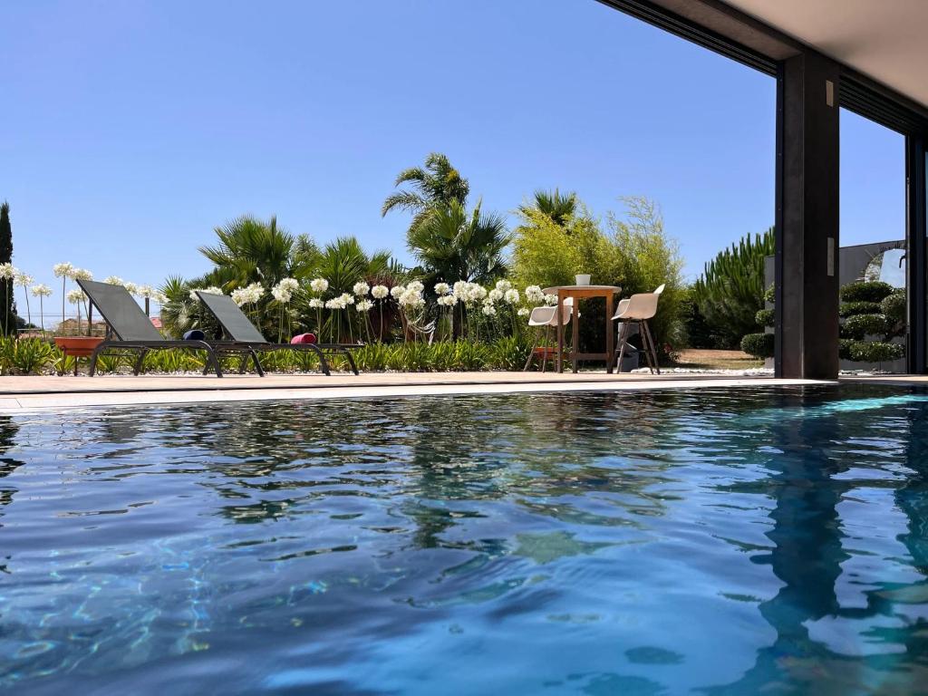 een zwembad met blauw water in een huis bij House with Garden in Bombarral - 100 m², Shared Pool in Barrocalvo