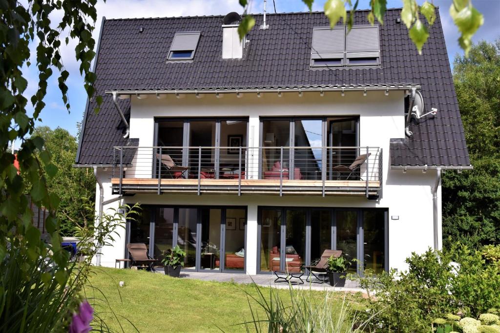 a house with large windows and a balcony at Ferienwohnungen Vogelsang in Saalhausen