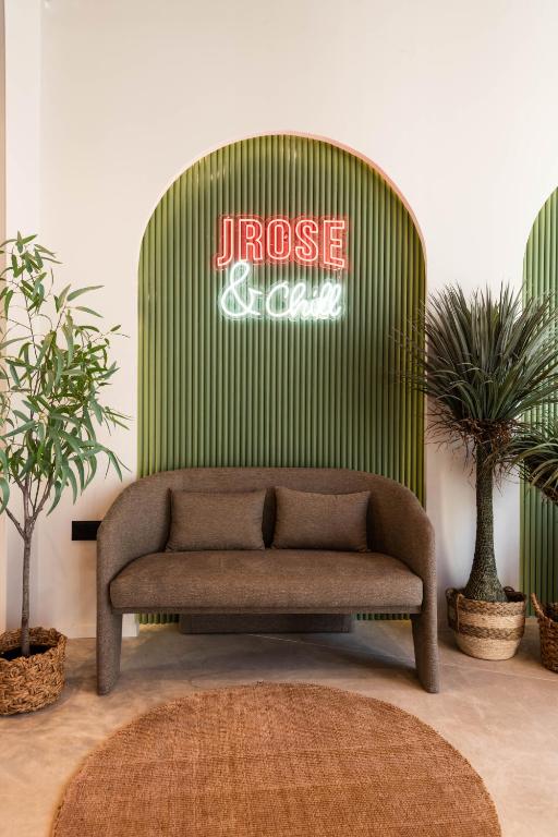 a couch in front of a green wall with a sign at Jrose Hotel in Jerusalem