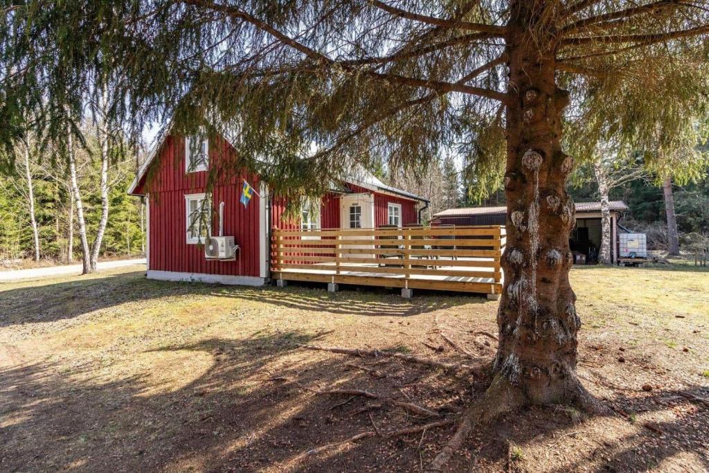 ein rotes Haus mit einem Zaun und einem Baum in der Unterkunft KRO958 Hamneda - Torsgård 2 in Traryd
