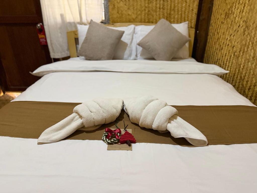 a towel animal laying on top of a bed at Hometown Pai Boutique Bungalow in Pai