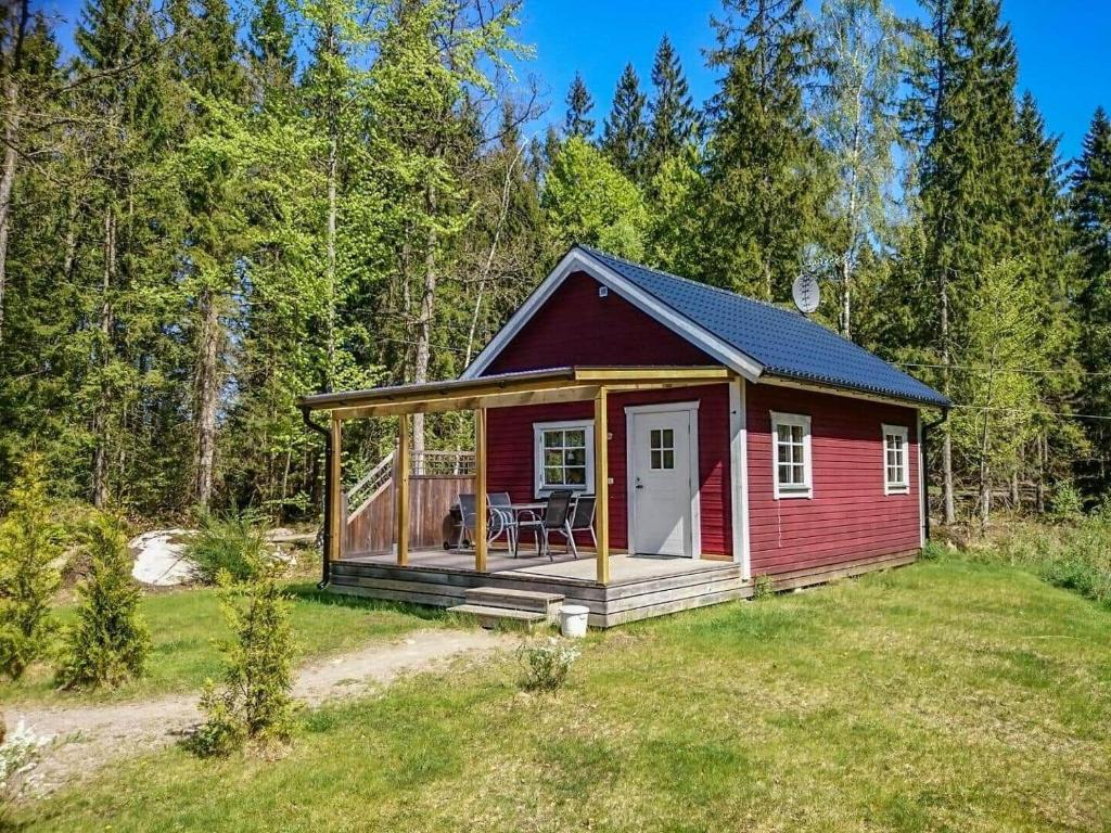 una piccola casa rossa con un ponte in un campo di KRO893-Hallaryd-Kalvshult-Vaestergard-42 a Kalvshult