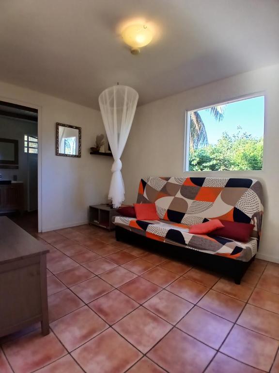 een woonkamer met een bank en een raam bij La Kaz Kako in Sainte-Rose
