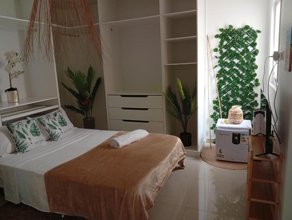 ein Schlafzimmer mit einem Bett und einer Kommode in der Unterkunft Four Palms Guest House in Praia