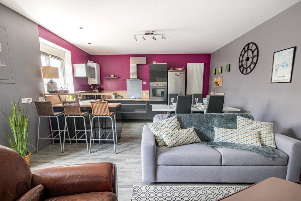 a living room with a couch and a kitchen at Le Vincennes, simple et atypique ! in Cholet