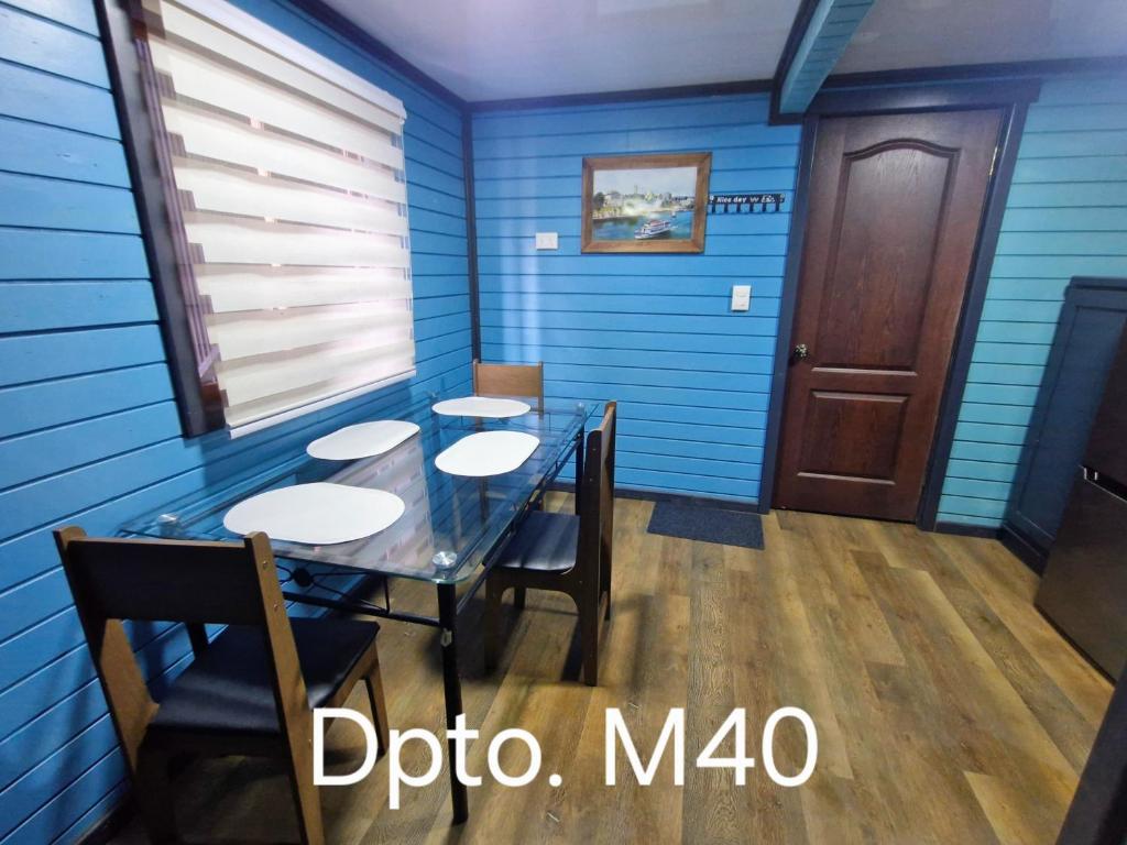 una sala da pranzo con pareti blu e tavolo con sedie di Wildepartamentos Valdivia TM a Valdivia