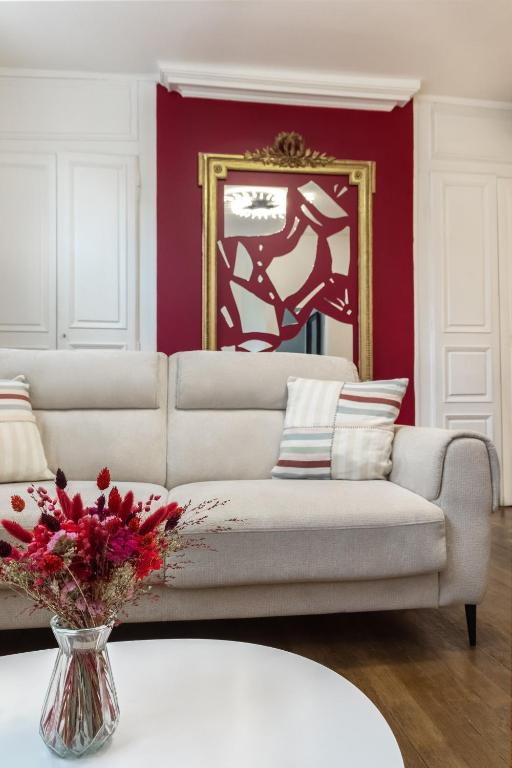 a living room with a couch and a vase of flowers at 2 Chambres, Les Dentellières de la Cathédrale in Troyes