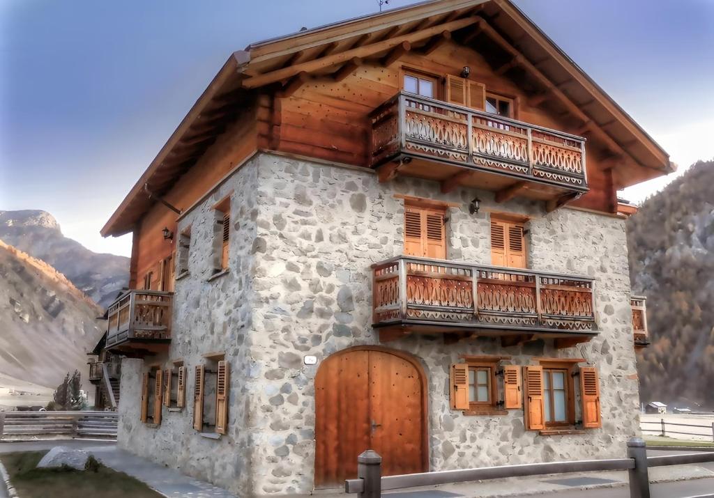 una vecchia casa con una porta di legno e un balcone di Martin Haus a Livigno