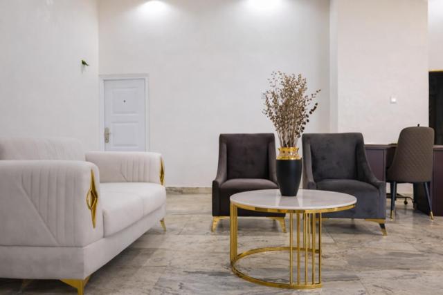 a living room with a couch and a table and chairs at Royal Modak Resort & Hotel in Ibadan