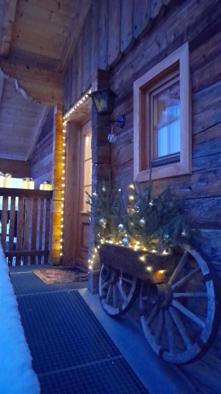 un albero di Natale su un carro davanti a una casa di Ferienwohnung Dienerhof a Grosskirchheim