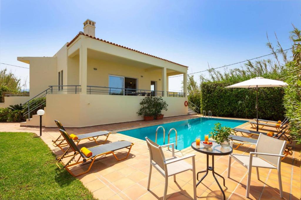 a villa with a swimming pool and a house at Villa Aggeliki by Villa Plus in Pírgos Psilonérou