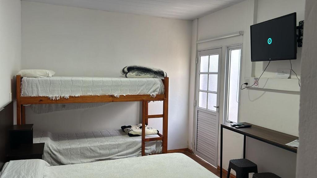 een kamer met 2 stapelbedden en een flatscreen-tv bij Las marias in Paso de los Libres