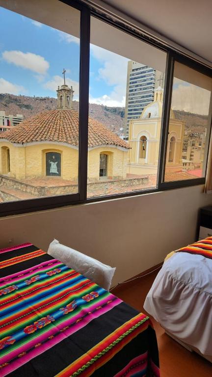 a bedroom with a window with a view of a church at Plaza murillo in La Paz