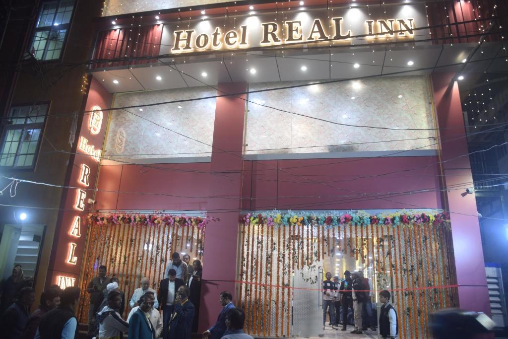 a hotel real inn with people standing outside of it at night at HOTEL REAL Inn in Muzaffarpur