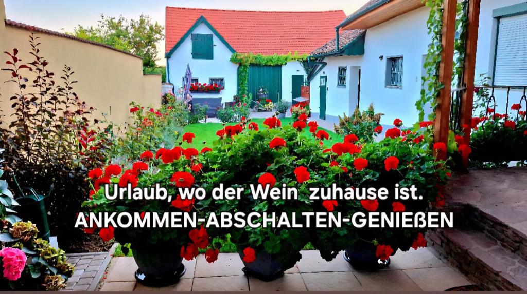 a garden with red flowers in front of a house at FERIENHAUS Weinviertel in Pernersdorf