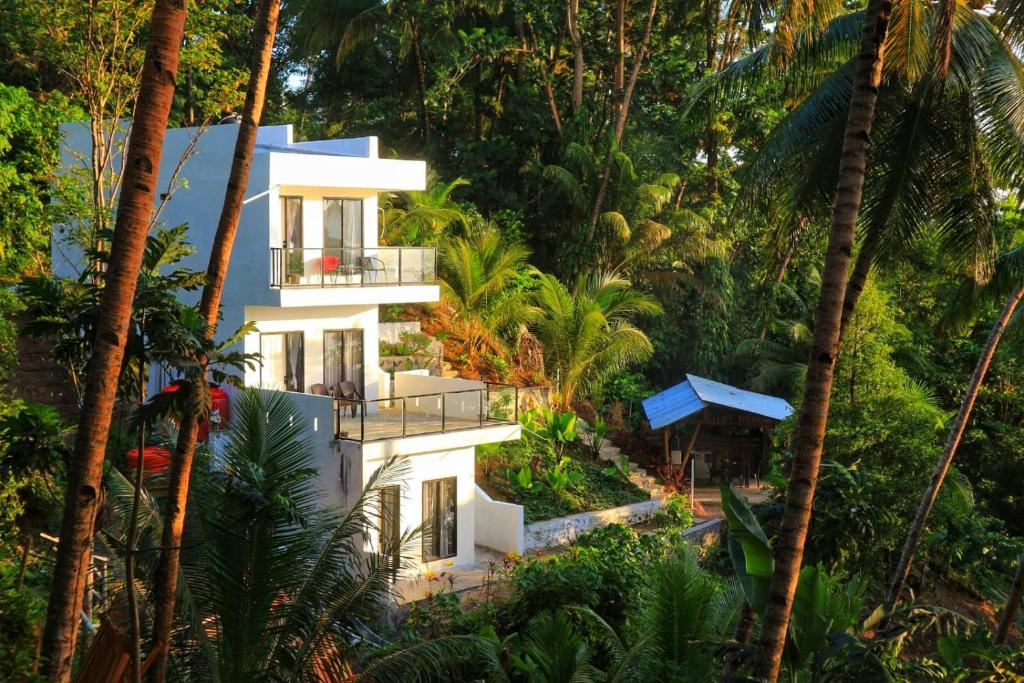 a house in the jungle with palm trees at SIRUS Resort Tagulandang in Kisihang