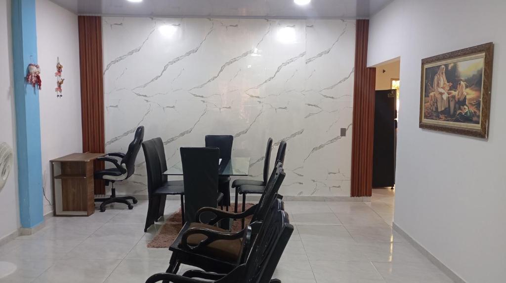 a meeting room with chairs and a marble wall at Cabaña Rochy in Coveñas