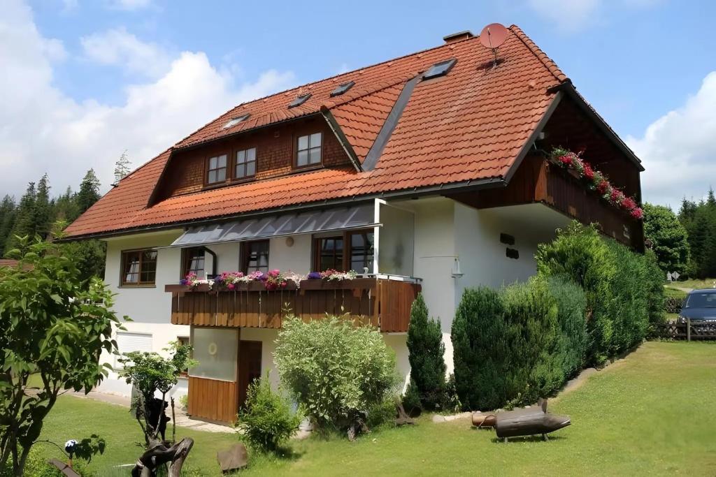 a white house with a red roof at Gästehaus Waldhüsle in Friedenweiler