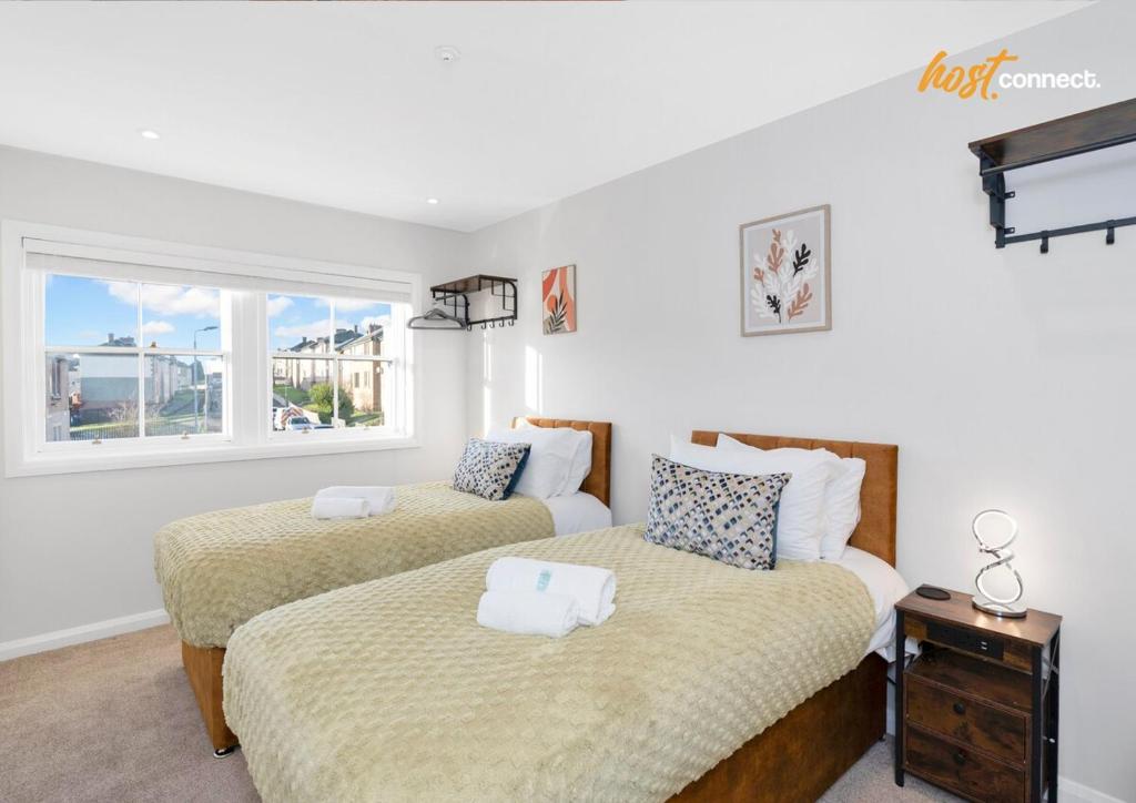 a bedroom with two beds and a window at Comfortable 2 Bed Airdrie Flat w Private Parking in Airdrie