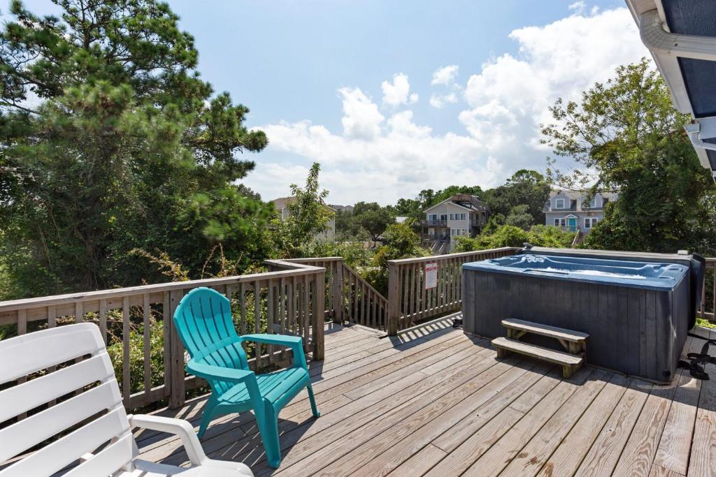 a deck with a blue chair and a hot tub at 1602 - Here To Stay in Corolla