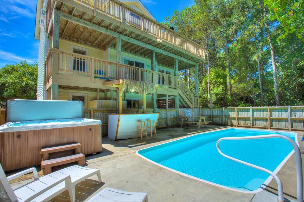 a house with a swimming pool and a deck at 1600 - 5 O`clock Somewhere in Corolla