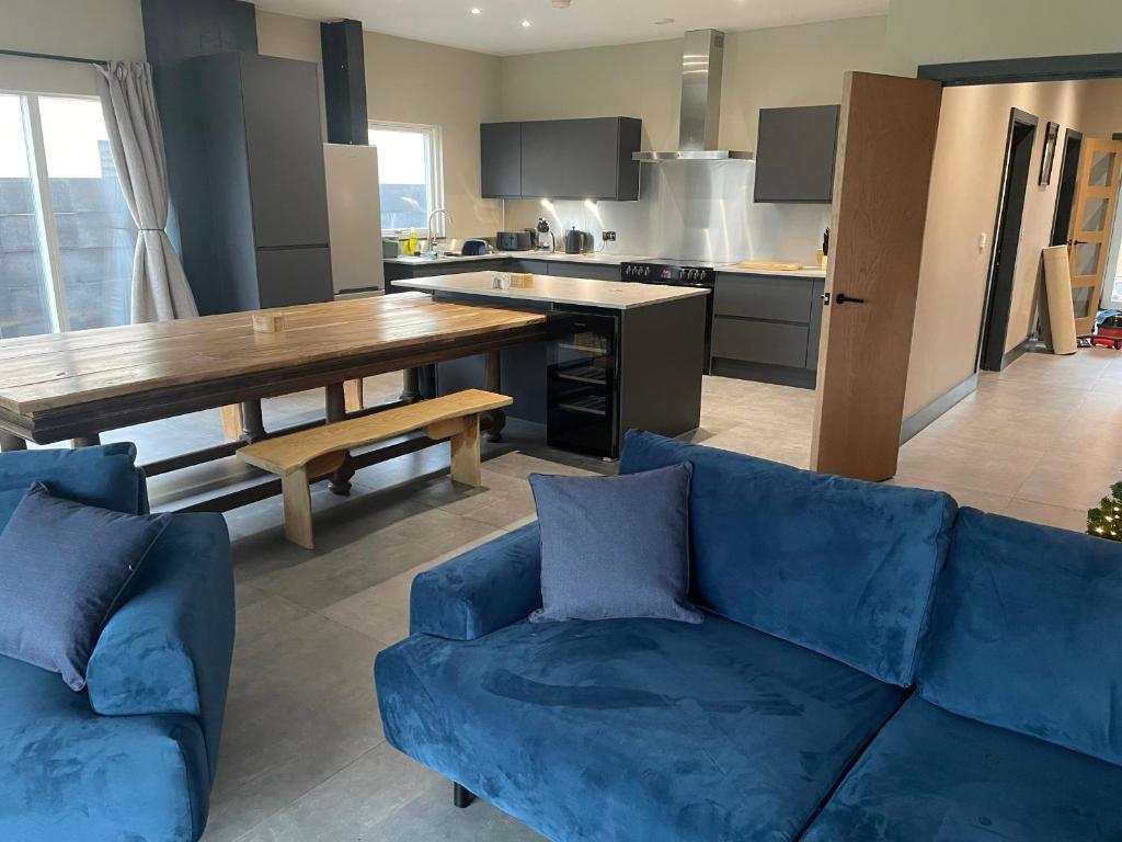 a living room with a blue couch and a kitchen at Spring Meadow in Durham