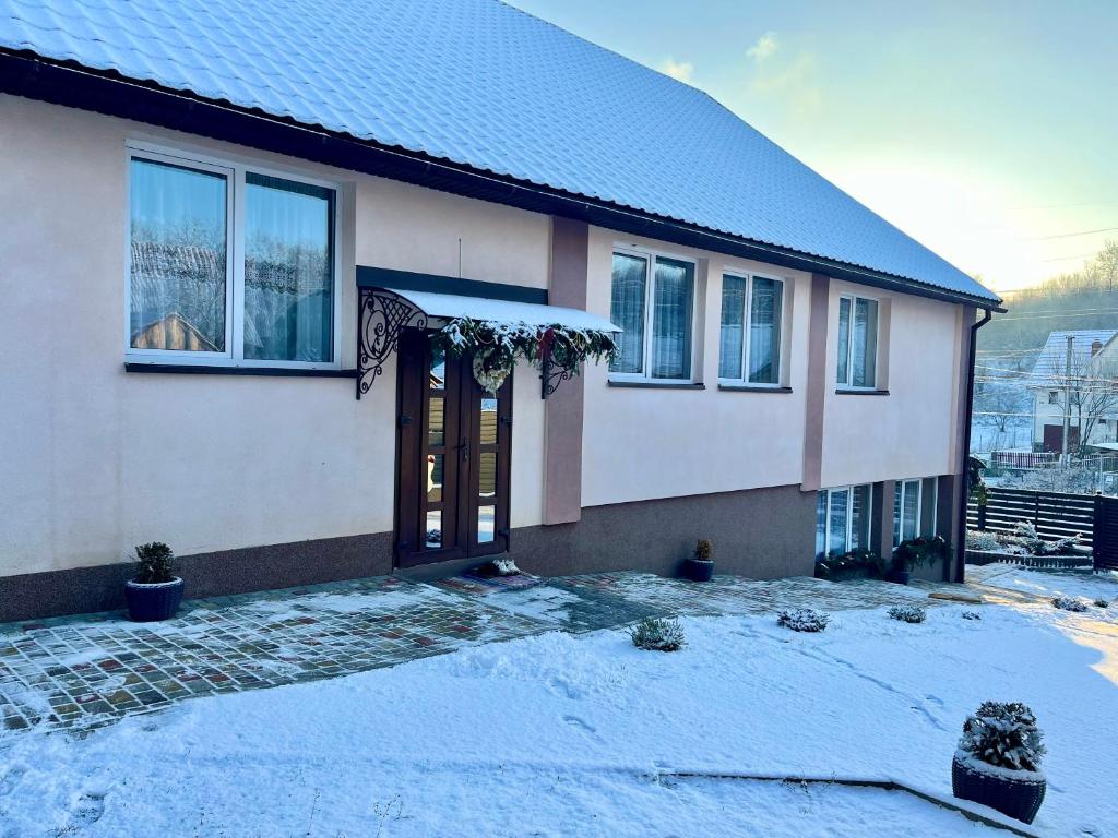 une maison avec de la neige devant elle dans l'établissement У Лариси, à Solochyn
