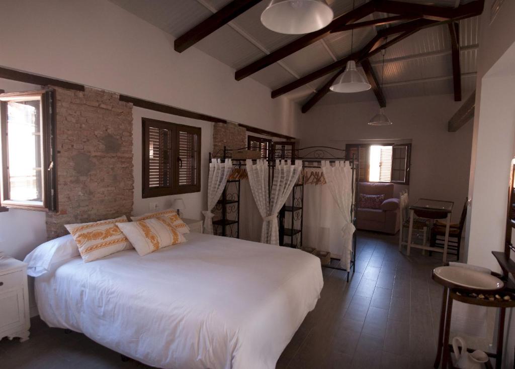 1 dormitorio con 1 cama blanca grande en una habitación en Patio de Arance, en Málaga