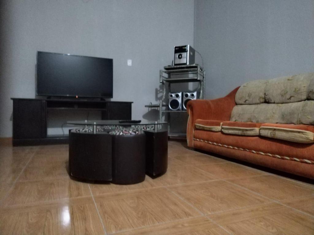 een woonkamer met een bank en een flatscreen-tv bij Departamento in Ilo