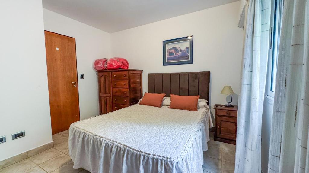 een slaapkamer met een bed met oranje kussens erop bij Quinta La Gloria in La Plata