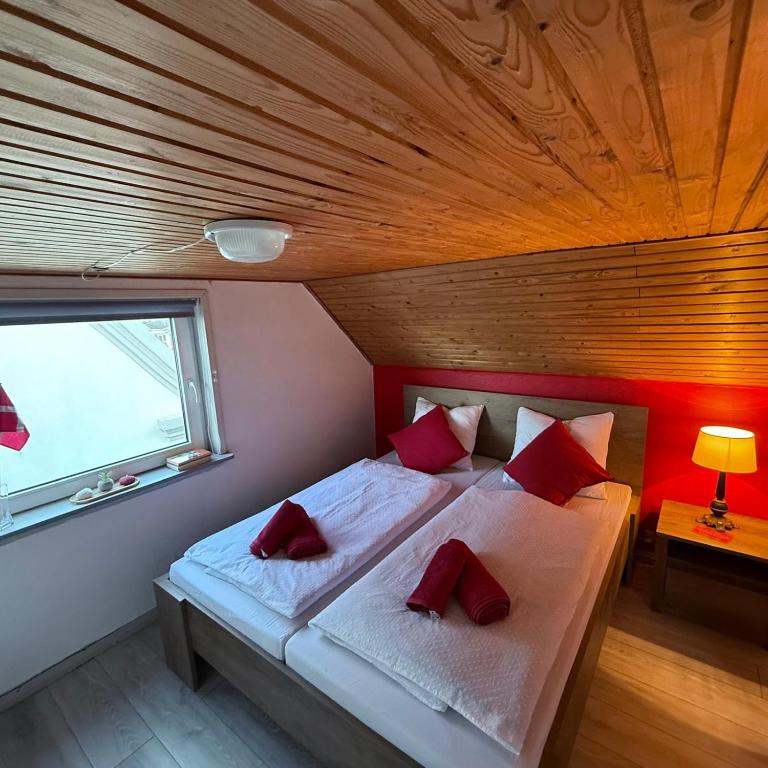 a bedroom with a bed with red pillows on it at Stanza in zona turistica in Hirtshals