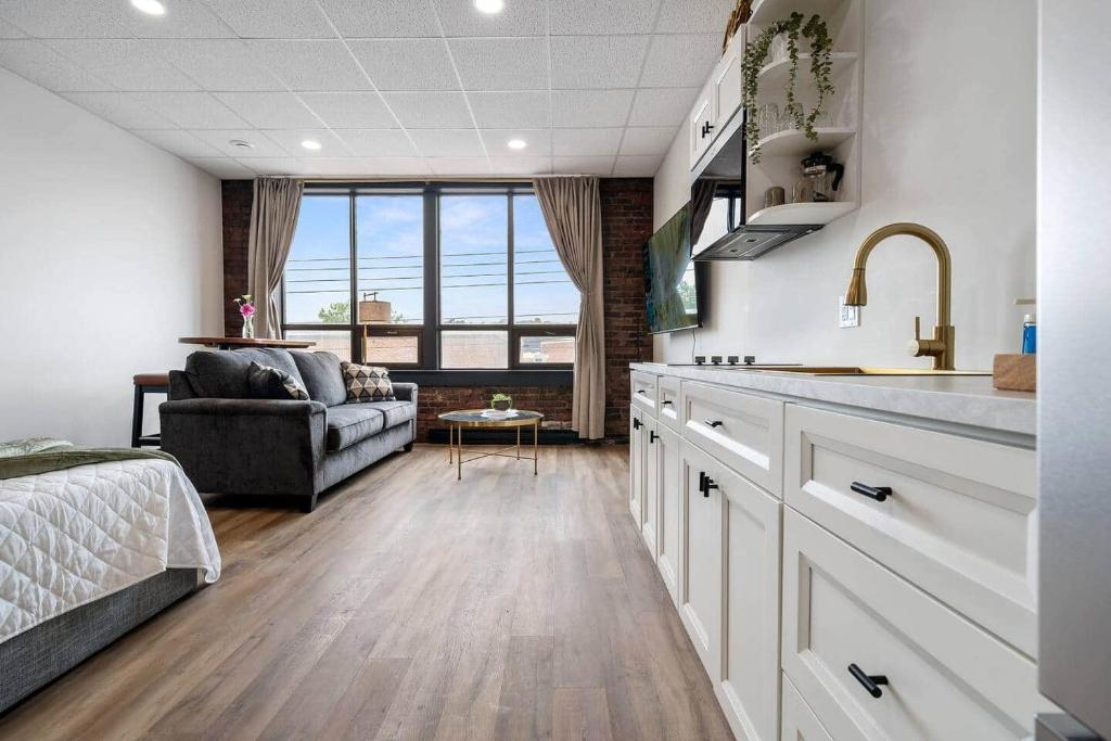 a kitchen and living room with a couch and a table at Golden Hour @TheMillRowsSuites in New Glasgow