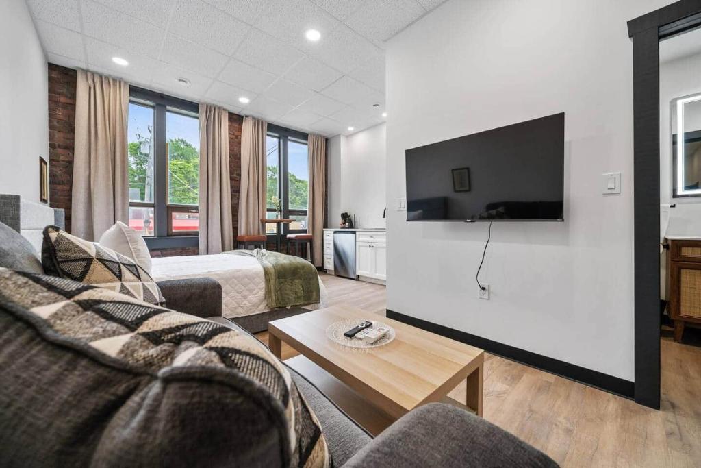 a hotel room with a couch and a tv at The Classic @TheMillRowsSuites in New Glasgow