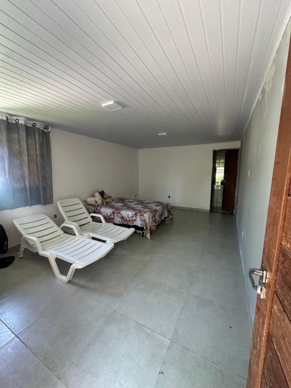 a room with two beds and two chairs in it at Espaço massagueira in Marechal Deodoro