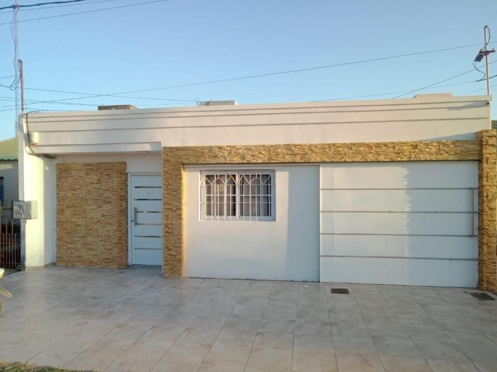 a garage with a white garage door and a window at Casa moderna en barrio in Villa Ángela