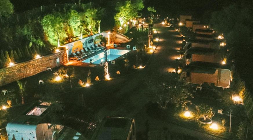 a street at night with a swimming pool and street lights at Güneş' te Karavan Otel in Karaburun